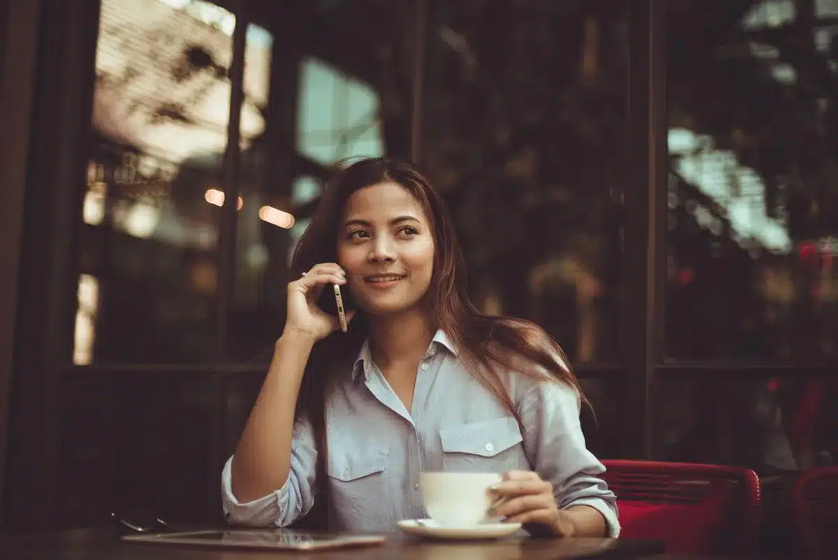 A hand holding a phone with a blurred background suggesting bad news