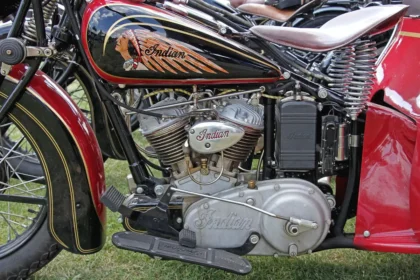 Vintage sidecar parked in a small garage with magazines in the sidecar and a helmet on a bench