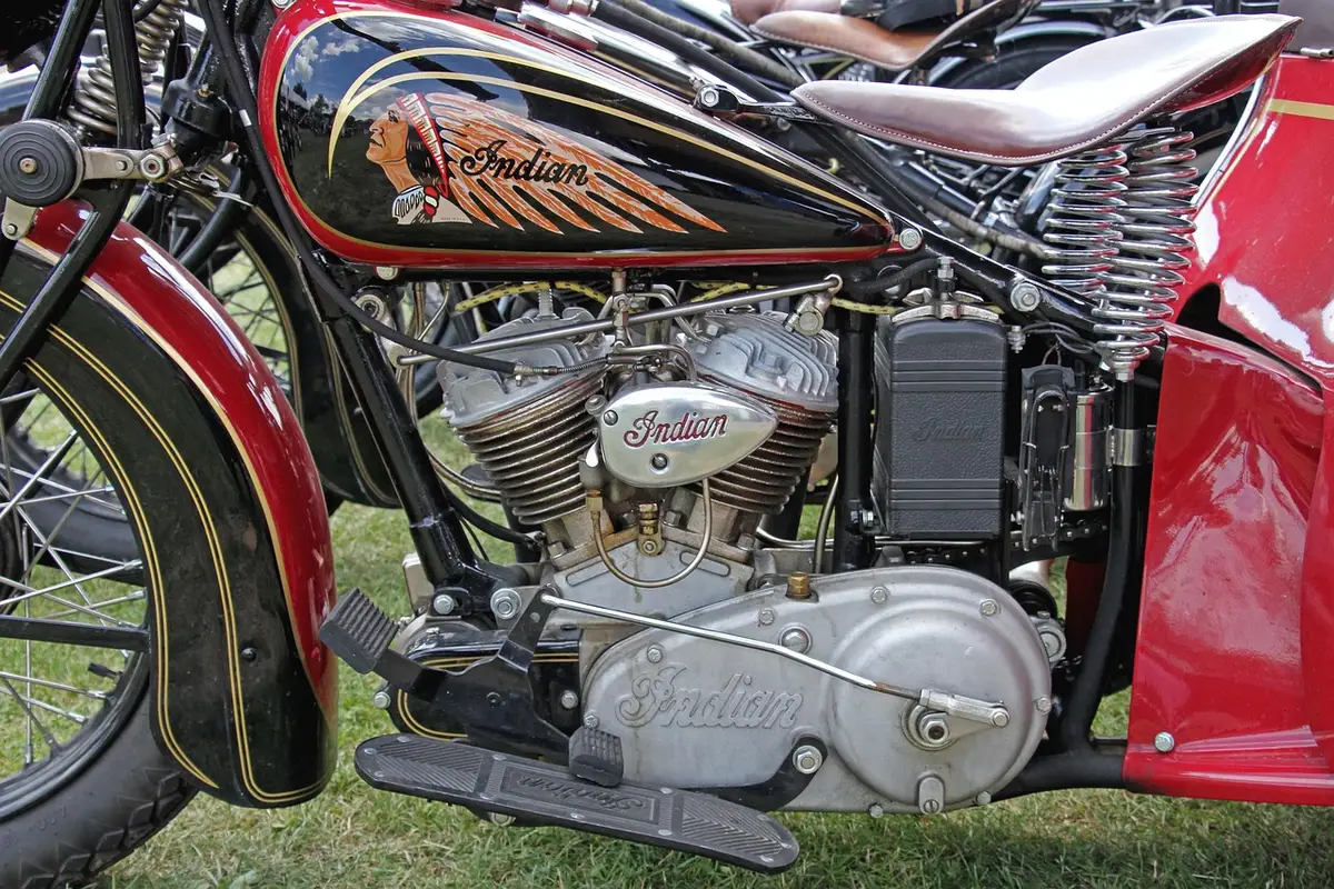 Vintage sidecar parked in a small garage with magazines in the sidecar and a helmet on a bench
