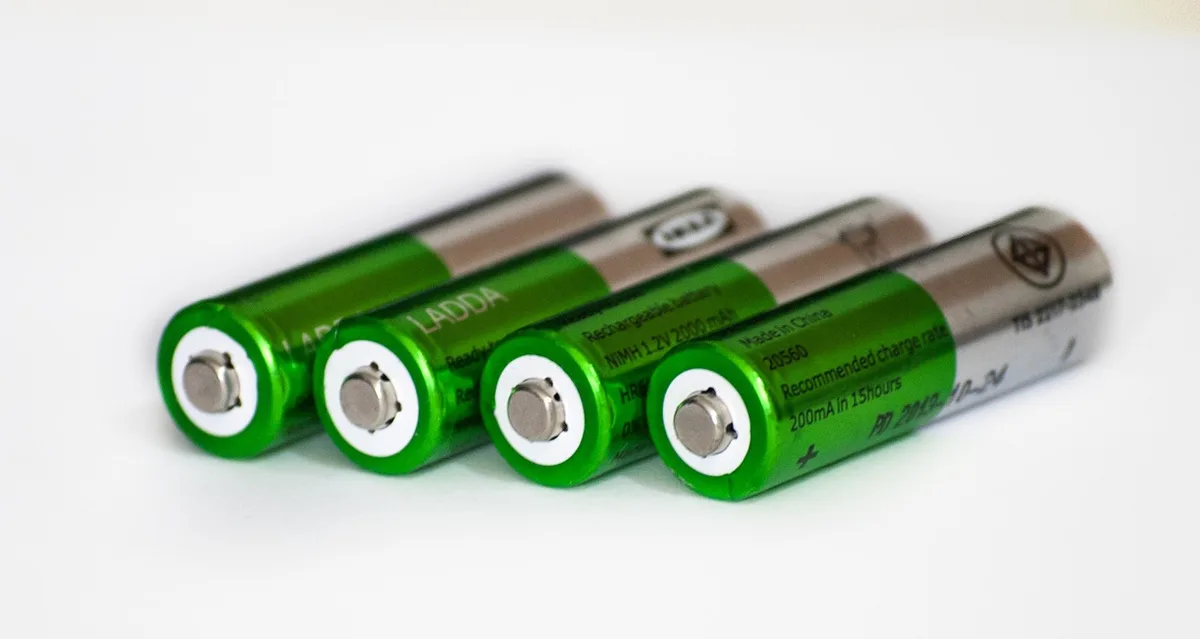 Removable 21700 rechargeable battery beside a compact charger