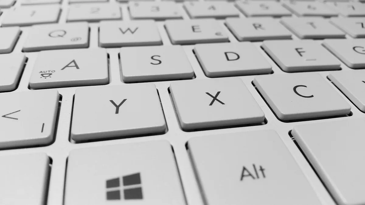 Hands typing on a retro-style keyboard with BASIC on screen