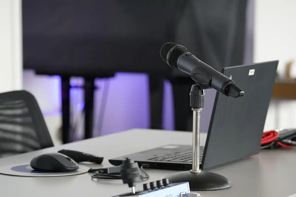 iPad in an adjustable cradle mounted on a desk with a compact controller