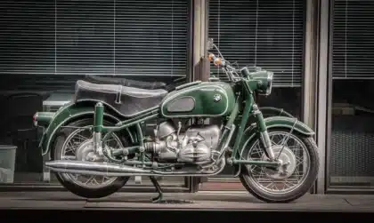 Close-up of a naked motorcycle engine and underfloor exhaust parked on an urban street