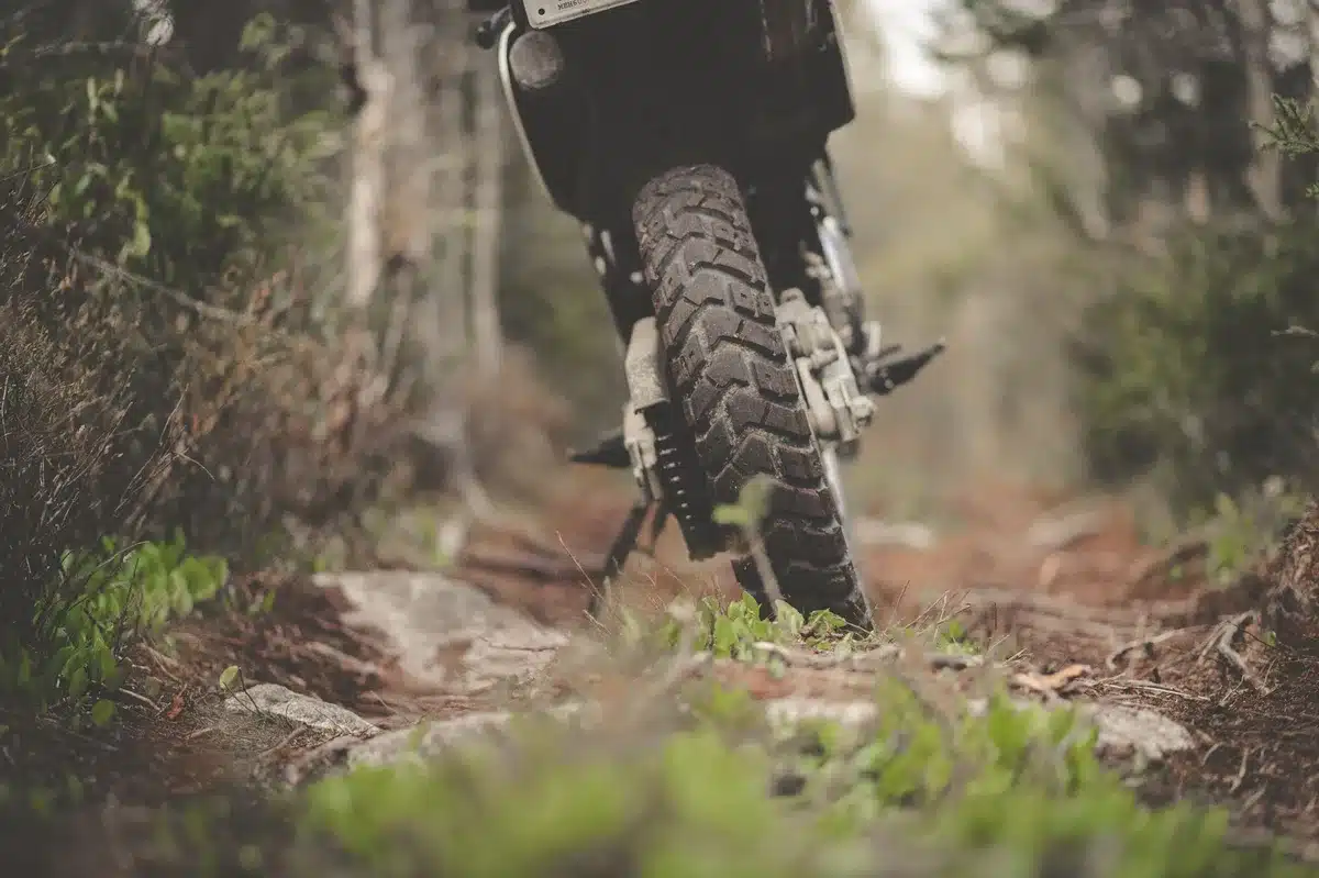 Close-up of a motorcycle tire tread with a packed saddlebag at the roadside