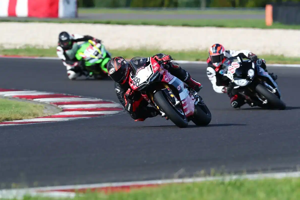 Race leader on a flat-track bike leading a pack at speed