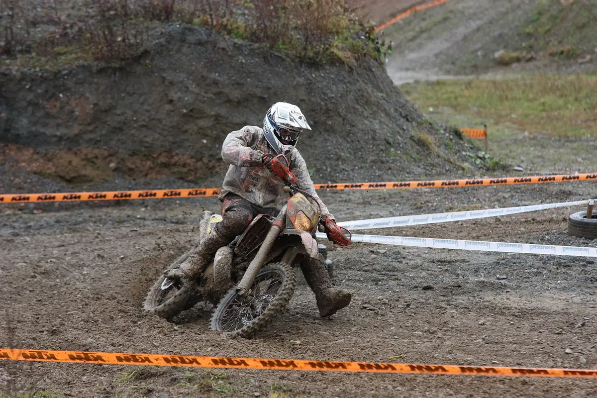 Multiple riders crossing a dirt track finish line within fractions of a second