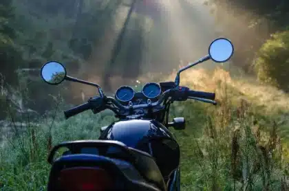 Silhouette of an adventure motorcycle on a gravel moorland track, wide bars and knobbly tyres visible