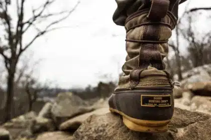 Pair of enduro motorcycle boots on a muddy trail with buckles visible