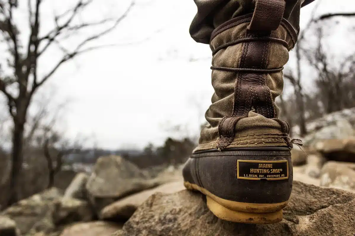 Pair of enduro motorcycle boots on a muddy trail with buckles visible
