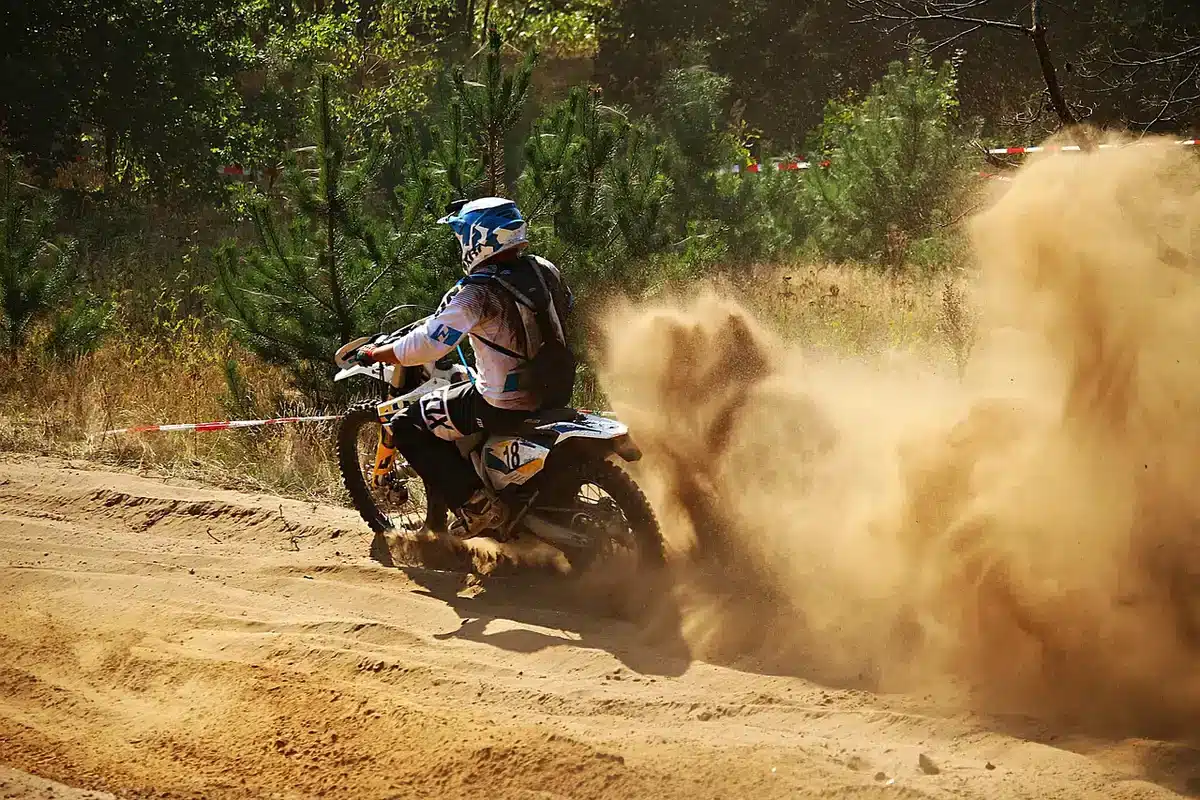 Group of anonymous riders practicing off-road on a muddy trail