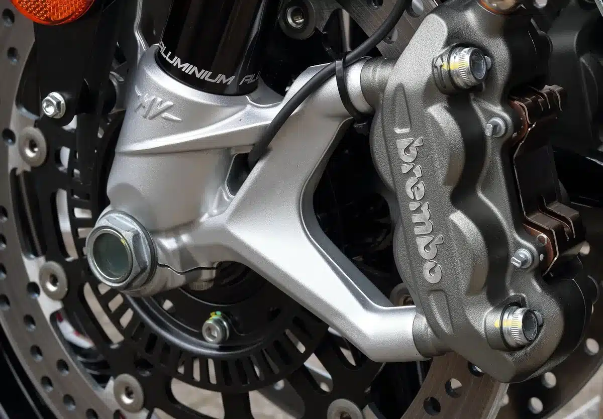 Close-up of a four-piston radial Nissin front brake caliper on a sportbike wheel