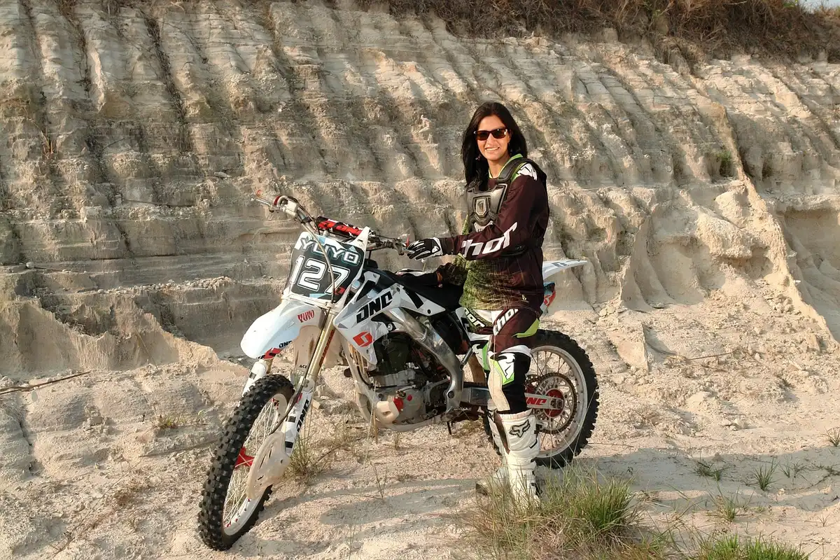 Rider standing on footpegs beside an adventure motorcycle showing upright ergonomics