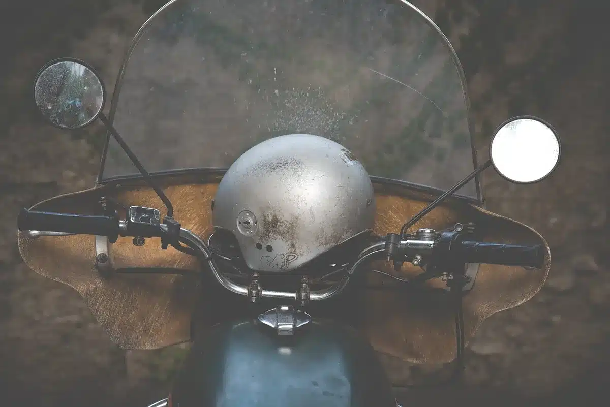 Gloved hands on an adventure bike handlebar with windscreen and bash plate