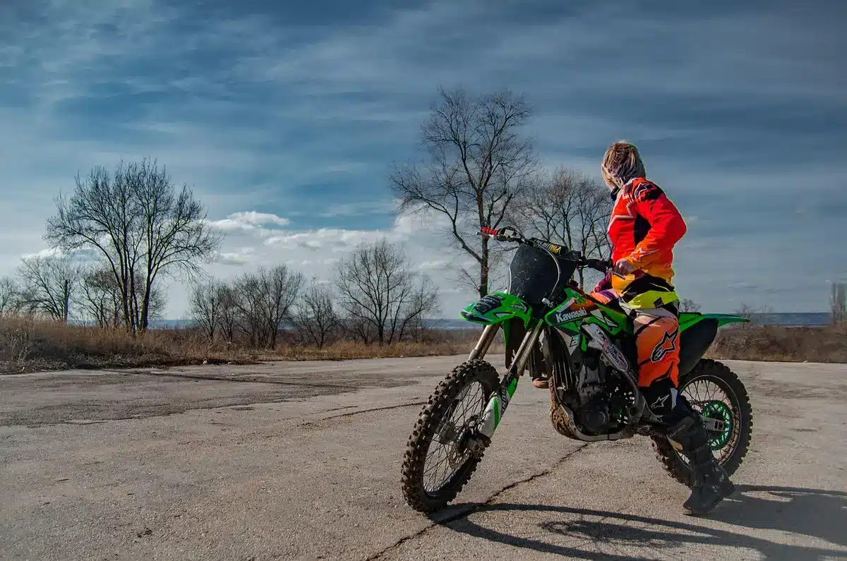 Rural dirt road at dusk with a parked motorcycle and a locked crate