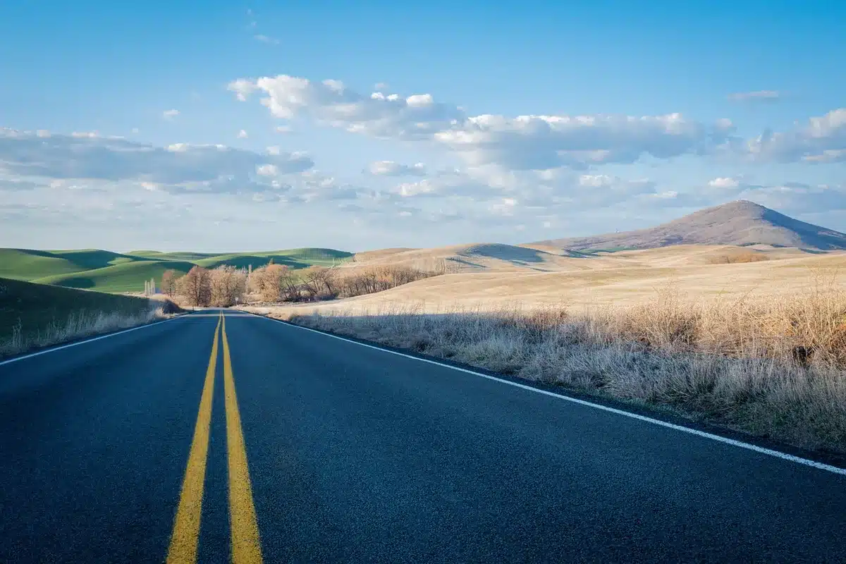 Motorcycle on a long open American highway at sunset