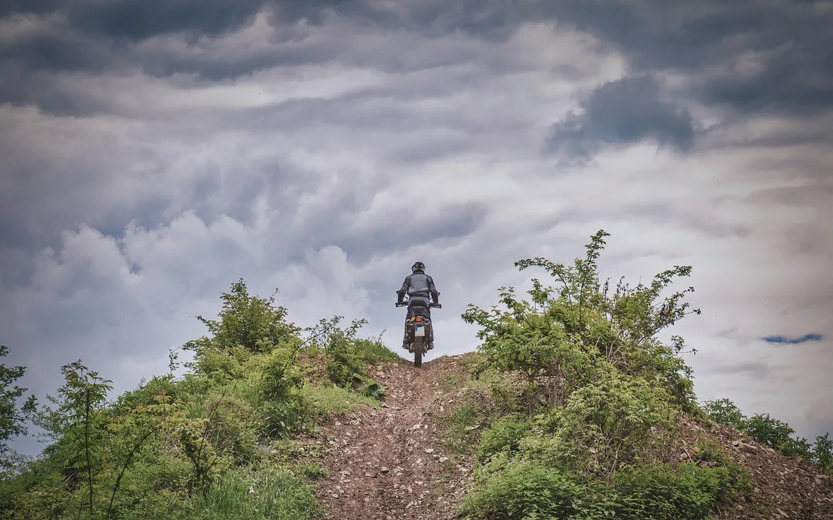 Dirt bike tyre splashing muddy water on a rural track