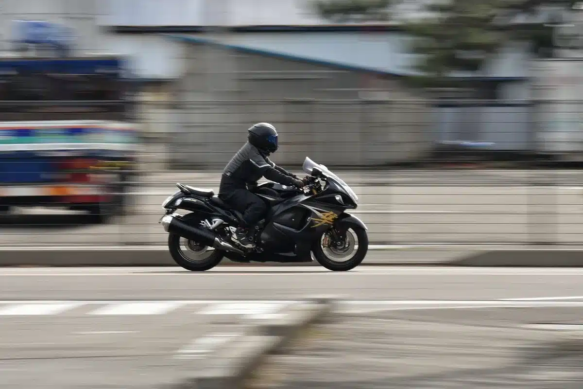 Two mechanics working on unbranded superbike fairings in a racetrack paddock