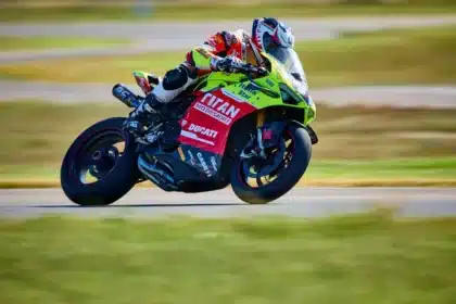 Wet racetrack paddock with a motorcycle silhouette and helmet on a bench