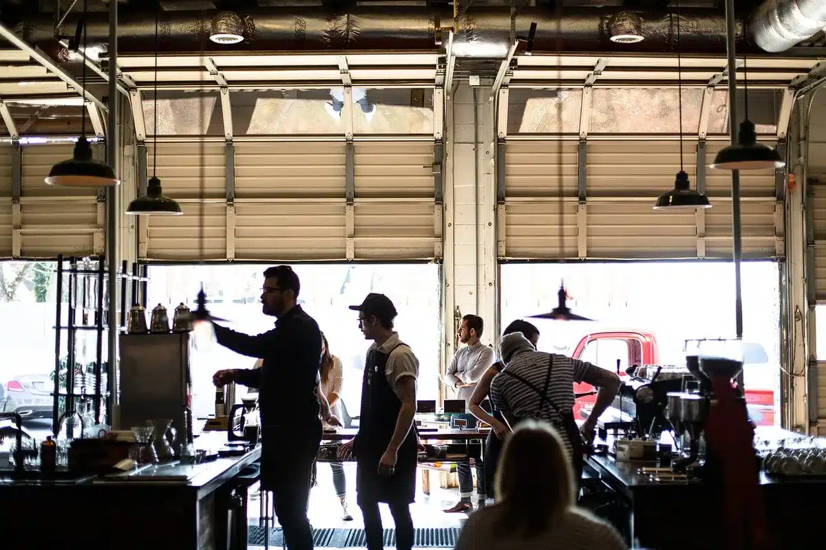 Two riders chatting inside a motorcycle dealership beside bikes and parts