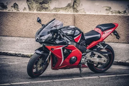 Two anonymous sport motorcycles in a sunny paddock with tyres and tools