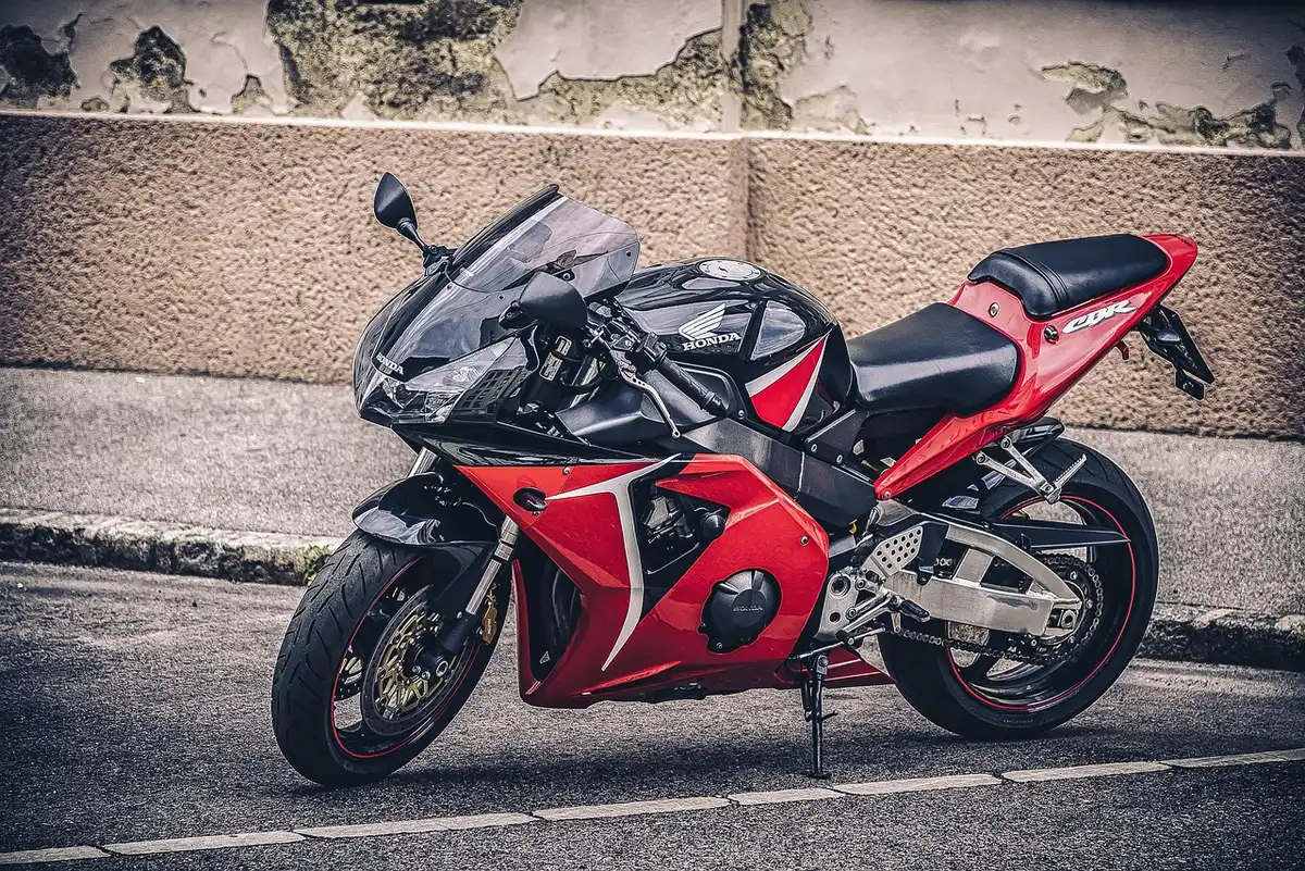 Two anonymous sport motorcycles in a sunny paddock with tyres and tools