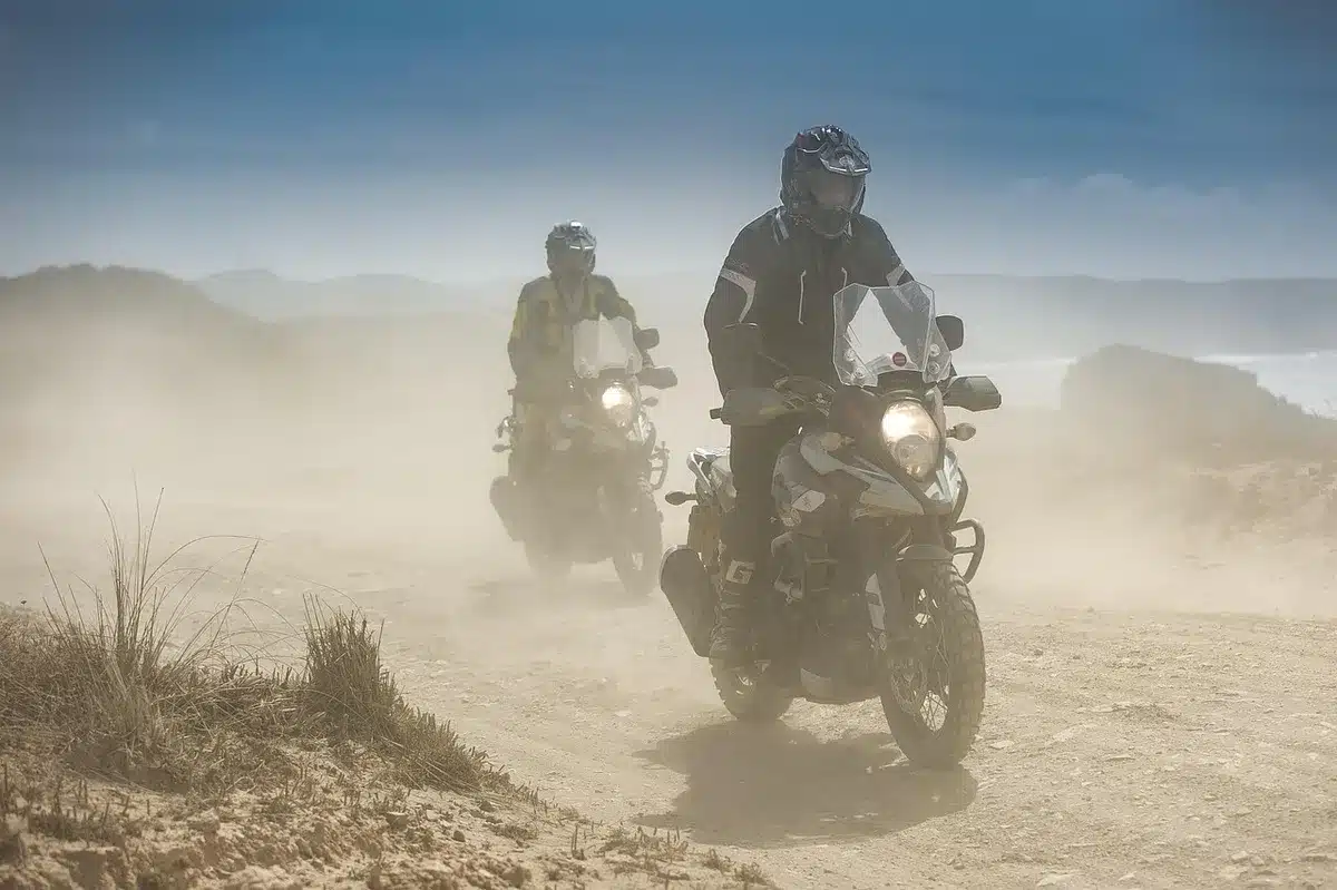 Two touring motorcycles on a remote road, packed luggage visible