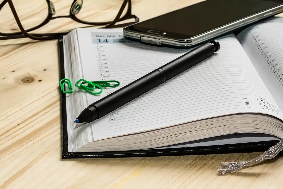 Editorial calendar and notes spread on a desk with a pen