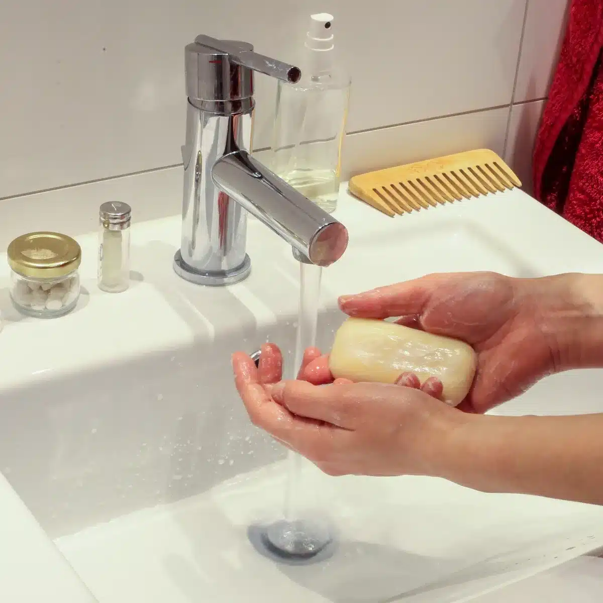 Close-up of hands turning a manual washing drum to show how the Divya operates
